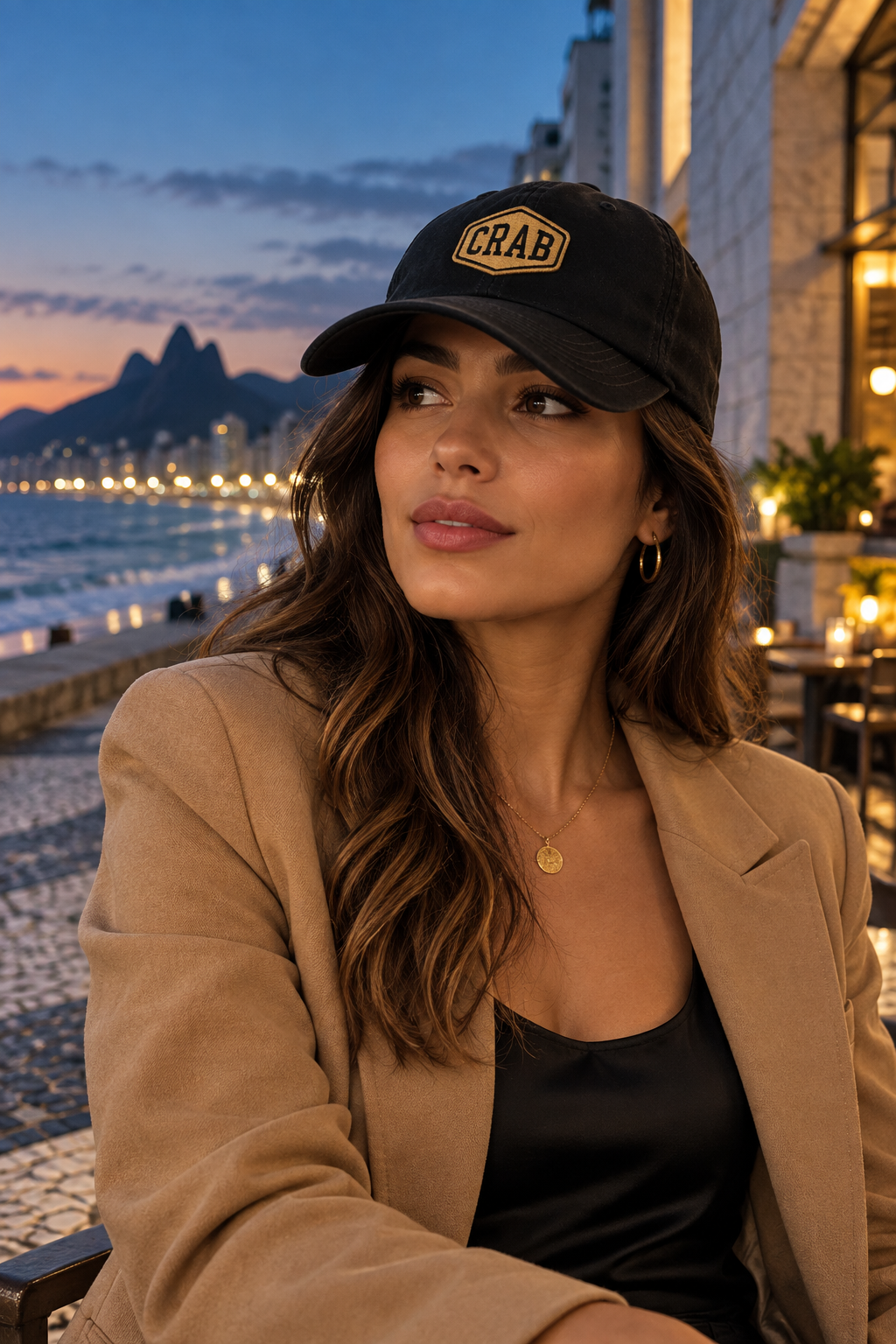 Mulher usando o dad hat preto CRAB em um calçadão costeiro ao anoitecer